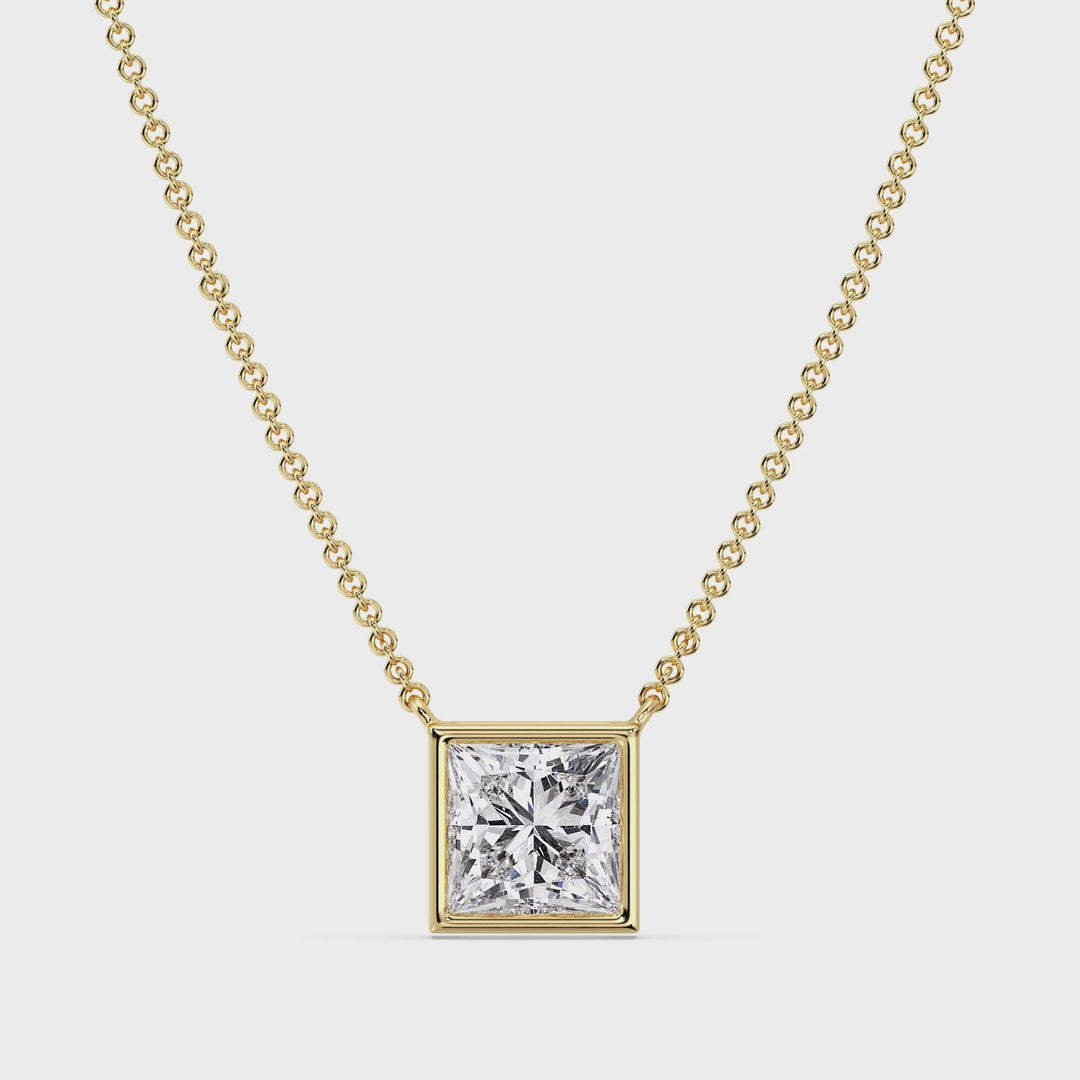 A close-up video showcasing a stunning 2 Carat Princess-Cut Lab-Grown Diamond Bezel-Set Pendant Necklace in Yellow Gold. The video highlights the dazzling brilliance of the E/VS IGI-Certified diamond, securely set in a sleek bezel setting. The vibrant yellow gold chain and pendant frame the diamond beautifully, creating a luxurious and contemporary aesthetic. The necklace is displayed from various angles, emphasizing its craftsmanship, elegance, and radiant sparkle in different lighting.
