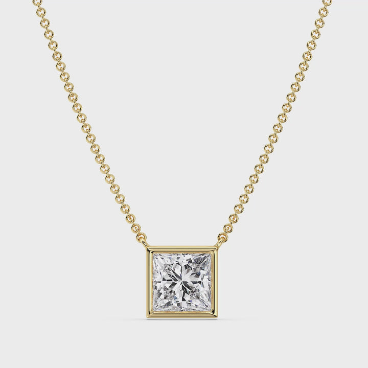 A close-up video showcasing a stunning 2 Carat Princess-Cut Lab-Grown Diamond Bezel-Set Pendant Necklace in Yellow Gold. The video highlights the dazzling brilliance of the E/VS IGI-Certified diamond, securely set in a sleek bezel setting. The vibrant yellow gold chain and pendant frame the diamond beautifully, creating a luxurious and contemporary aesthetic. The necklace is displayed from various angles, emphasizing its craftsmanship, elegance, and radiant sparkle in different lighting.
